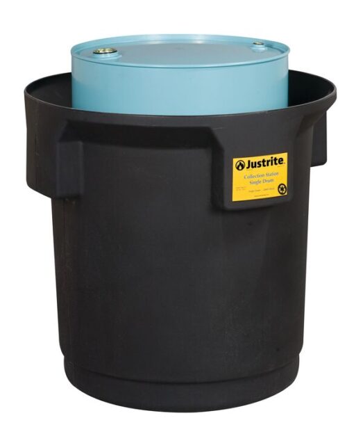 A blue drum rests inside a black spill containment basin with a yellow Justrite Collection Ctr Sgl Drm, Eco Bk label. The basin has robust vertical ridges for secure and eco-friendly containment.
