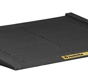 A black, slightly inclined Justrite Ramp, designed for the 2+ Drum Accm Ctr Eco Blk system, has a ridged surface with side edges and features a small yellow label with a black logo in the lower right corner.