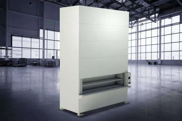 Tall, white Vidir Pan Carousel in an empty warehouse with large windows and a high ceiling, offering customizable shelving systems for efficient inventory management.