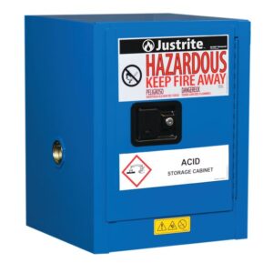 The Justrite Cabinet, Haz Mat Cnttop 4G Sc, is blue with a Hazardous: Keep Fire Away label and marked as an Acid Storage Cabinet. It has a protruding handle and safety icons warning against chemical storage. Perfect for secure storage needs.
