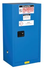 The Justrite Cabinet Haz Mat Compac 15G SC in blue has a lockable door, features corrosive symbols and warnings like Hazardous Keep Fire Away, and prominently displays the brand label for safe storage of hazardous materials.