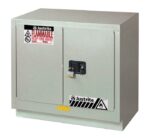 The Justrite Cabinet Fmhd Chmc 23G Man Slv is a gray metal flammable storage unit with two doors, a black handle, and a padlock. It includes fire hazard labels, ensuring safety by mitigating fire risks.