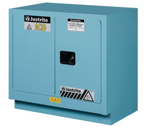 The Justrite Cabinet Fmhd Chmc 23G Sc Blu is a light blue metal storage unit, labeled Justrite Acid, featuring safety warnings, a secure black handle and lock, and hazard symbols for corrosive material storage.