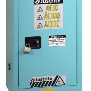 The Justrite Cabinet, Acid Cmp 12G, Man Blu for corrosive materials has a secure lock on the handle and displays safety symbols with labels in English, Spanish, and French.