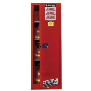 A tall Justrite Cabinet, Flam Slm 22G, Sc Red stands with its door slightly open, revealing shelves lined with flammable liquid containers. Multiple Flammable warning labels in English and Spanish adorn it for clear caution messaging.