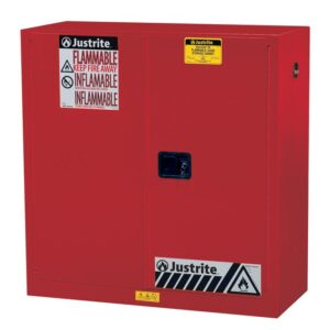 The Justrite Cabinet, Flam Sfty 30G Man Red, has a yellow label and front handle, featuring Flammable and Inflammable warnings with hazard symbols for safe flammable material storage.