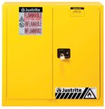 The Justrite Cabinet Cmbs P&I 40G Man Yel flammable storage cabinet features a bright yellow finish, a secure lock, English and French warning labels, black and white hazard symbols, and prominently displays the Justrite Cabinet brand logo for ensured safety and quality.