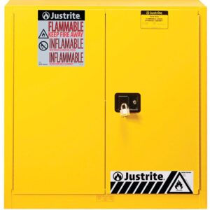 The Justrite Cabinet Cmbs P&I 40G Man Yel flammable storage cabinet features a bright yellow finish, a secure lock, English and French warning labels, black and white hazard symbols, and prominently displays the Justrite Cabinet brand logo for ensured safety and quality.