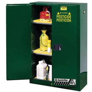 A Justrite Cabinet, Pest Sfty 45G Sc Grn, labeled Pesticide, stands open to reveal green shelves holding various chemical containers, a red fire extinguisher, a yellow sprayer, and white bottles.