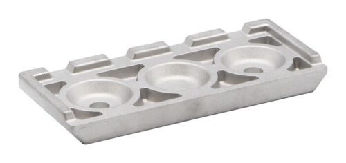 The Justrite Chock,At,Acc,3512,Clt boasts a sleek rectangular silver metal design with three circular indents at the center. Its angular sides and small rectangular top-edge accents add modernity to this functional piece.