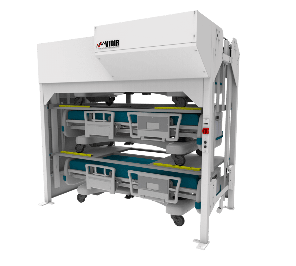 The Vidir Hospital Bedlifts system features a white automated storage unit with two blue medical beds stacked vertically, securely held in the metal frame. With a visible control panel, this customizable hospital bed storage solution efficiently conserves space and organizes equipment.