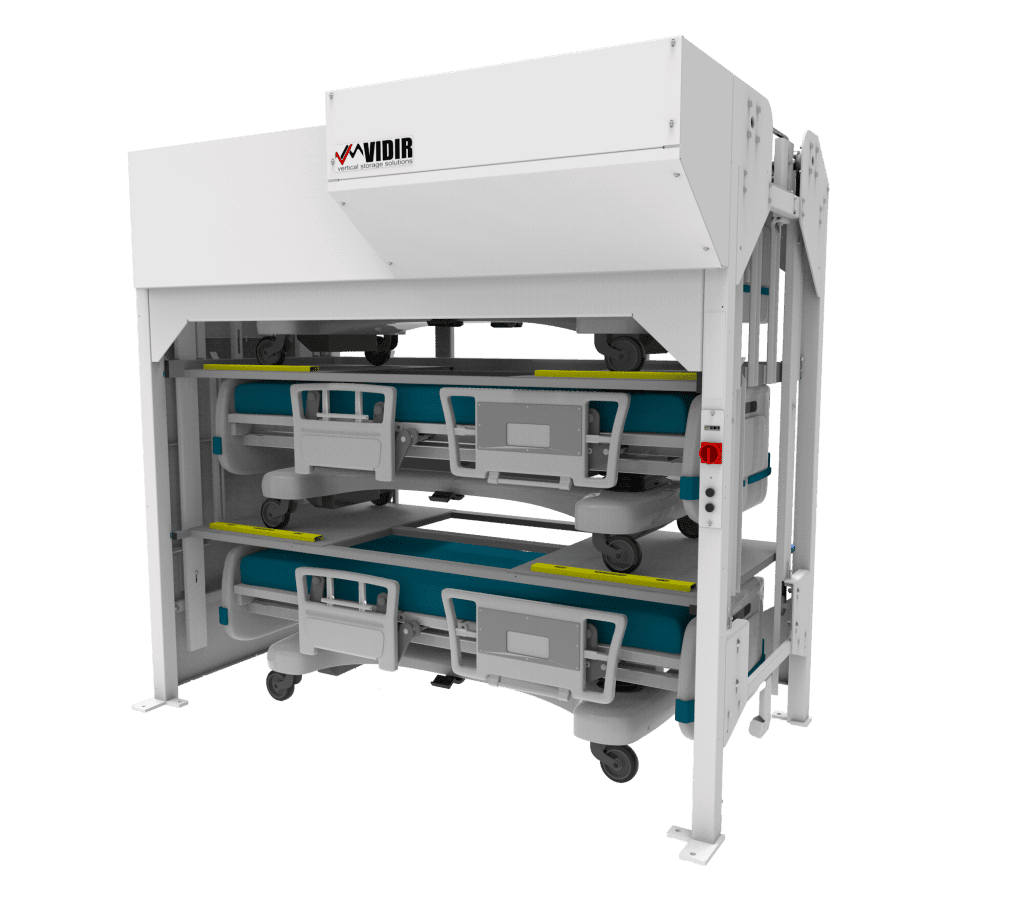 A vertical storage system designed for healthcare efficiency holds two hospital stretchers. The white metal frame, branded with Vidir at the top, showcases stretchers horizontally stacked with teal surfaces and gray wheels, embodying Healthcare Bed Lifts advanced solutions.