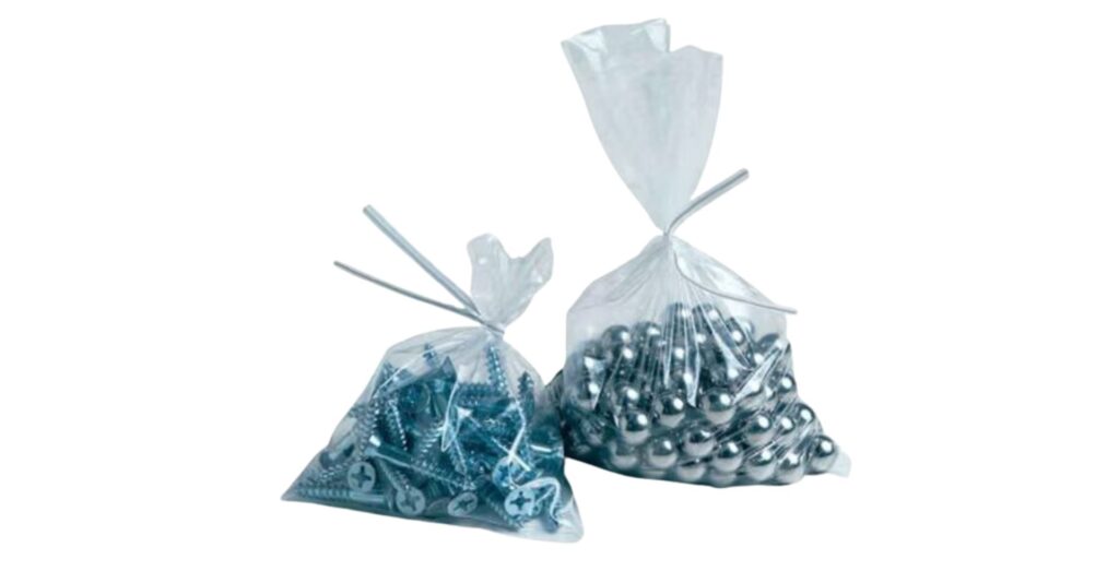 Two transparent poly bags, tied at the top, hold silver screws on the left and shiny metallic balls on the right. These economical packaging solutions are similar in size and set against a plain white background, highlighting their practical design.