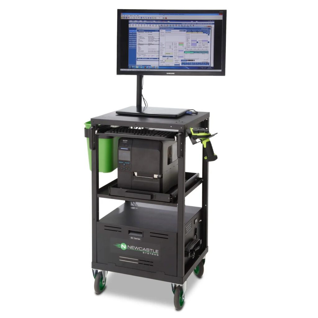 Mobile workstation with a mounted monitor displaying software, a printer on the middle shelf, and storage below. The powered cart, labeled Newcastle Systems, is on wheels for easy mobility and features green accents on the side holders.