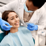 A dentist in a mask and gloves examines a smiling patient, embodying the essence of healthcare. The patient, seated comfortably in a dental chair and donning a blue protective bib, reflects the care provided in this professional dental office setting.
