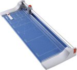 The Dahle 446 Premium Rotary Trimmer has a 36 cut length, blue grid cutting mat, silver rotary blade arm, orange blade handle with matching safety latch on a rectangular base for precision trimming.