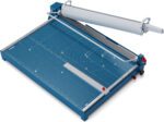 The Dahle 569 Premium Guillotine, boasting a 27 cut length, is a blue and silver paper cutter designed for easy use with a large handle. It ensures precision cutting with base measurement markings, a red adjustment knob, and a clear guide for paper or cardstock.