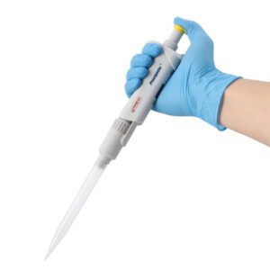 A gloved hand holds an MH-USA Precipette Pipette, Single-Channel, adjustable from 1000-5000μl, against a white backdrop. The gray and white pipette has a blue button and the hand wears a blue nitrile glove.