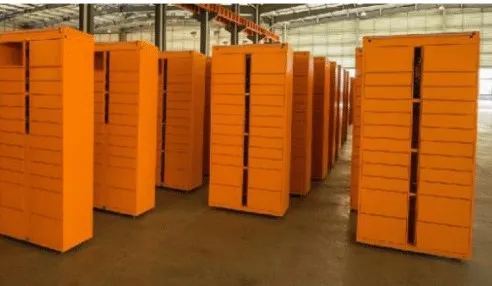 A warehouse interior with neatly arranged rows of tall, orange storage shelves, reminiscent of Utah parcel lockers. The shelves stand empty, exposing the smooth concrete floor beneath, while the roof showcases sturdy metal beams.