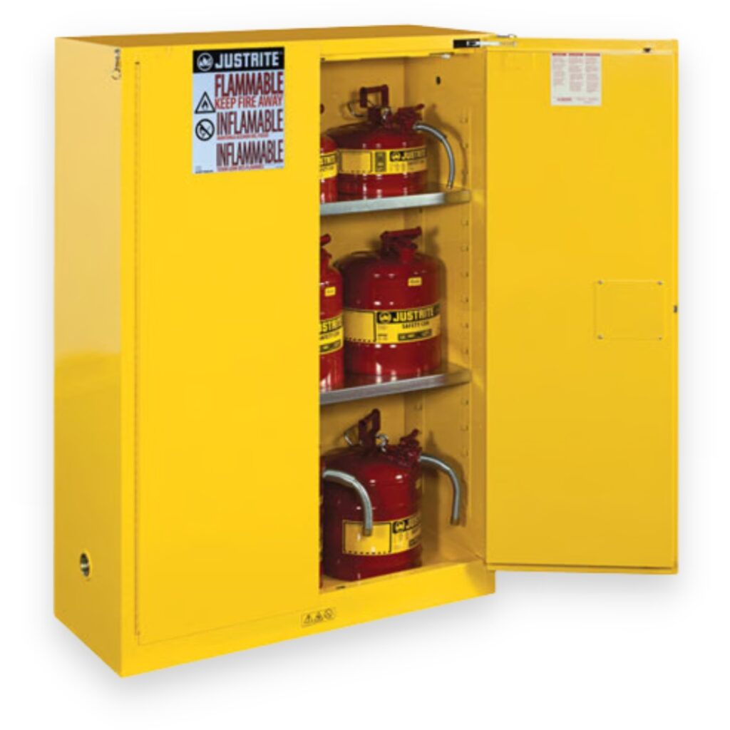 A yellow safety cabinet, made by Justrite, stands with the door ajar, revealing three shelves filled with red metal safety cans. The cabinet is adorned with warnings like Flammable and Inflammable, ensuring maximum precaution.