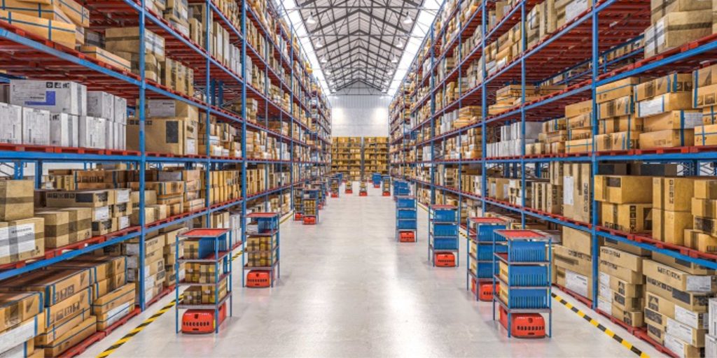 A spacious warehouse interior featuring organized shelving units filled with various boxes and materials. In the foreground, a worker wearing safety gear operates a forklift, carefully placing a pallet onto a high shelf. Bright overhead lighting illuminates the clean and orderly environment, highlighting clear pathways and well-labeled sections. Safety signage is visible on the walls, emphasizing the warehouse's commitment to safety and productivity.