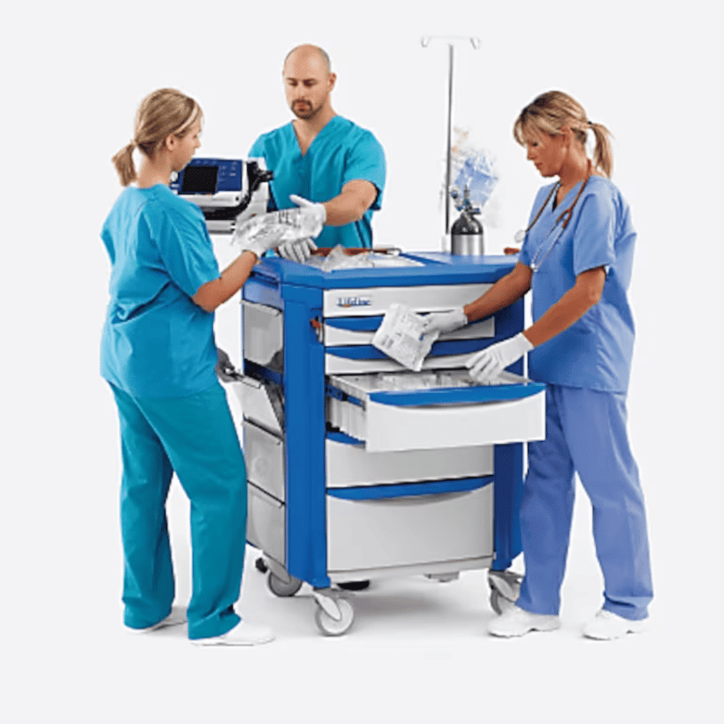 Three healthcare professionals in scrubs and gloves stand around a Lifeline crash cart. One is holding a medical device, while another opens a drawer filled with essential supplies. In the background, an IV stand can be seen.