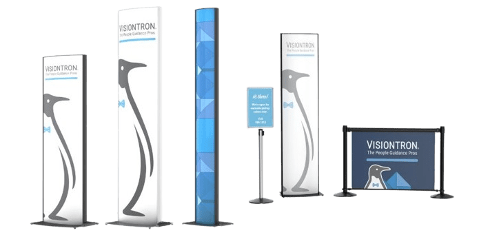 Displays with penguin graphics, tall banners, and a rectangular sign proclaiming Visiontron: The People Guidance Pros. One display uniquely combines informational signage with a geometric blue pattern and a small digital screen, offering prime branding opportunities.