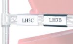 A close-up image features two clear 3 Quantum Label Holders. The first holder displays LH3C, and the second shows LH3B, set against a red container backdrop.