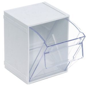 The Quantum Tip Out Bin, a clear plastic container with a polystyrene white cabinet, features one compartment with an angled lid that opens to 45° for easy viewing and access. Its dimensions are 5-1/4W x 4-3/4D x 6-1/4H, and it includes a handle with a label slot. Made in USA.