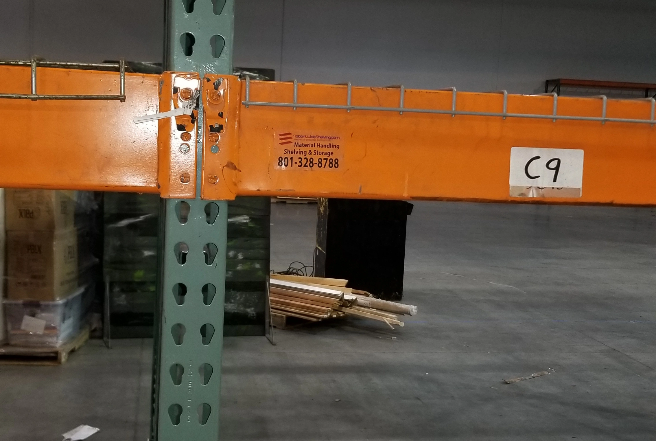 Close-up view of a damaged pallet rack beam, highlighting online pallet rack safety risks and the importance of regular inspections.